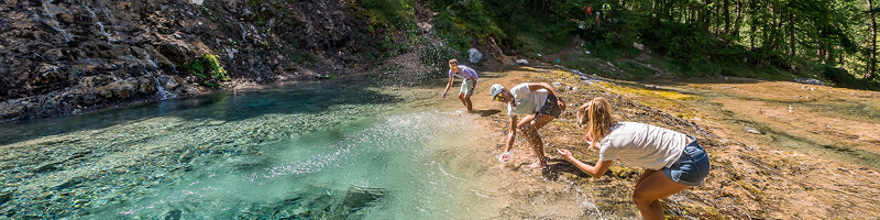 Se balader à Tignes en été - 3 personnes se rafraichissant au bord d'un point d'eau