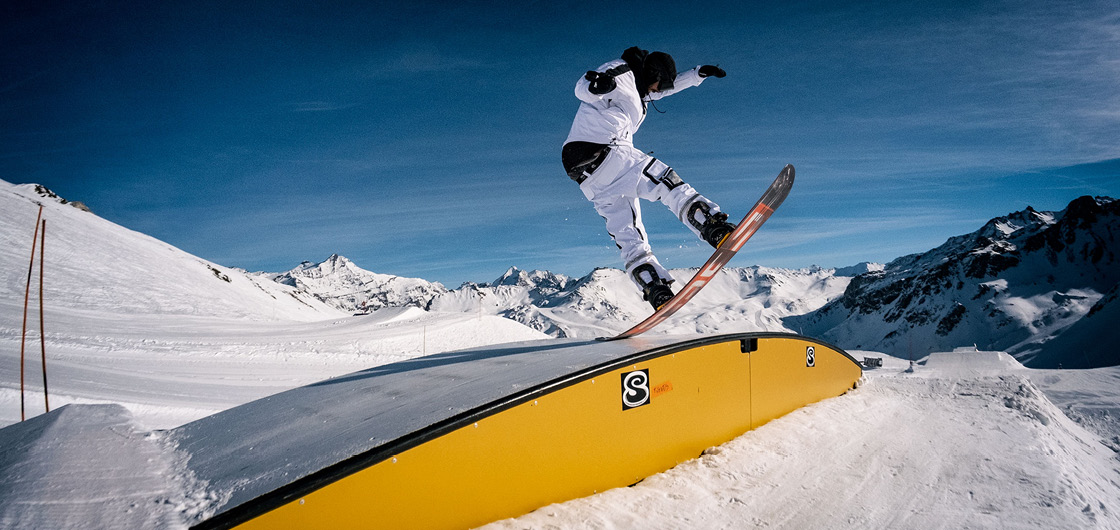 snowboardeur sur une box snowpark Tignes