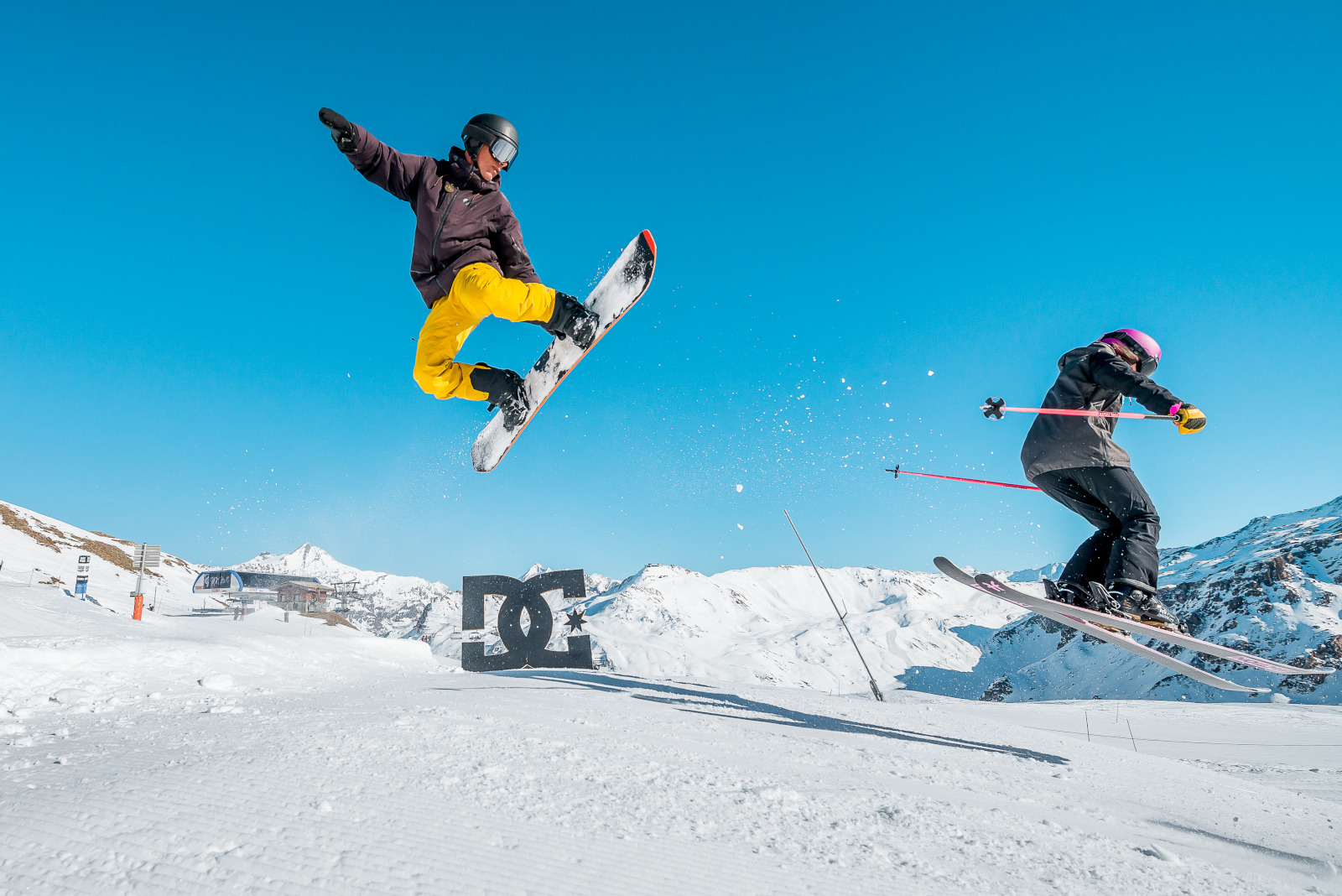 Snowboarder et skieur sur la zone freestyle de Tignes